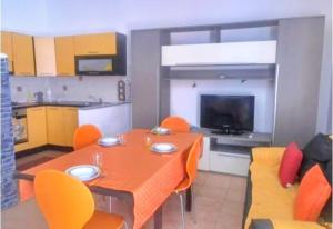 a dining room with a table and orange chairs at Casa Arborea in Sennori +22 photos