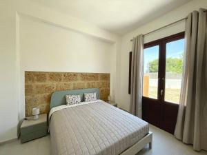 a bedroom with a bed and a large window at Asmara 10 in Trapani