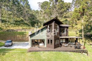 a tiny house with a porch and a hammock at Faxinal das Águas Retreat - 5min from downtown in Rancho Queimado