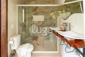 a bathroom with two sinks and a toilet at Faxinal das Águas Retreat - 5min from downtown in Rancho Queimado +29 photos