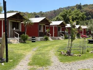 a row of red cottages in a yard at Cabañas ALAMEDA in Omitlán de Juárez