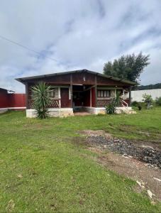 a small red house with a grass yard at Cabañas ALAMEDA in Omitlán de Juárez
