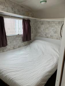 a bedroom with a white bed in a room at Retro stekje in Nieuwerkerk