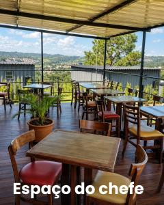 an outdoor patio with tables and chairs and windows at Villa Container in the Wine Route in São Roque