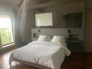 a bedroom with a bed with white sheets and a window at chambres d hotes ochene in Daix