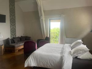 a bedroom with a bed and a couch and a window at chambres d hotes ochene in Daix