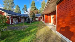 an exterior view of a house with a red wall at Virsun majoitus in Ikkeläjärvi