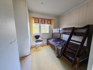 a bedroom with a bunk bed and a chair at Virsun majoitus in Ikkeläjärvi