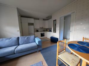 a living room with a blue couch and a table at Virsun majoitus in Ikkeläjärvi