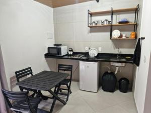 a small kitchen with a table and a microwave at Loft da Árvore in Petrópolis