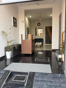 a lobby with a table and a clock on the wall at Amrit bela in Haridwār