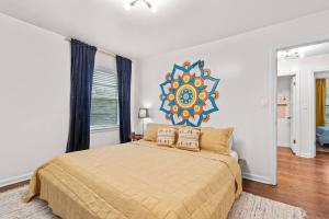 a bedroom with a large bed with a painting on the wall at Bright 3BR | 25 mins to Arrowhead | Groups & Pets in Mission