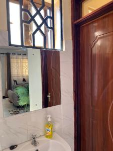 a bathroom with a sink and a mirror at Mimi Home Stays in Voi