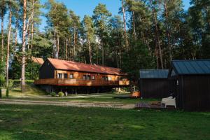 a large wooden house in the middle of a forest at Krokodyl Sport&Spa in Mielno