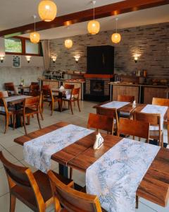 a restaurant with wooden tables and chairs and a fireplace at Krokodyl Sport&Spa in Mielno