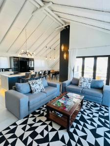a living room with two blue couches and a table at Frank Road At The beach in St Francis Bay