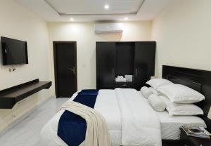 a bedroom with a large bed with a tv on the wall at Mak Palace Hotel in Sialkot