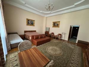 a bedroom with a bed and a couch and a table at Edelweiss in Almaty