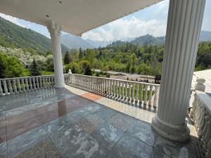 a porch with columns and a view of the mountains at Edelweiss in Almaty