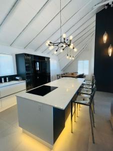 a kitchen with a white counter and some chairs at Frank Road At The beach in St Francis Bay