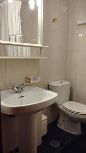 a white bathroom with a sink and a toilet at Hotel Vista Alegre in Torredonjimeno