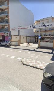 a car parked in front of a large building at Hotel Vista Alegre in Torredonjimeno