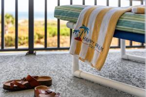 a towel hanging on a bench next to a pair of sandals at Spanish Main - Cocoa Beach Oceanfront Condos near Port Canaveral in Cocoa Beach