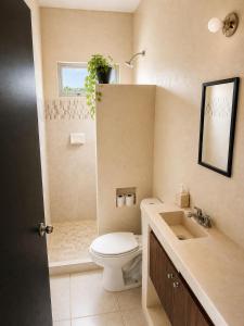 a bathroom with a toilet and a sink at Casa Coral in Puerto Morelos