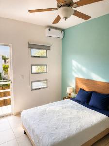a bedroom with a bed and a ceiling fan at Casa Coral in Puerto Morelos