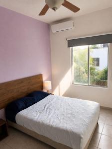 a bedroom with a large bed and a window at Casa Coral in Puerto Morelos