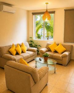 a living room with two couches and a table at Casa Coral in Puerto Morelos