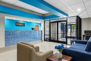 a living room with a blue accent wall at Clarion Pointe Jesup in Jesup