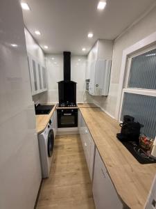 a kitchen with a stove and a washer and dryer at Marine Résidence in De Panne