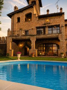 a house with a swimming pool in front of a building at Il Castelletto di Gomo - Relax nella natura con SPA privata outdoor in Godiasco