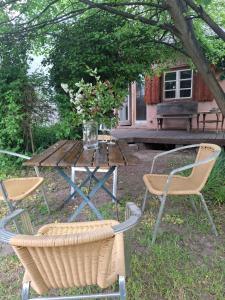 a picnic table with chairs and a vase of flowers at Ferienhaus Witta in Radebeul
