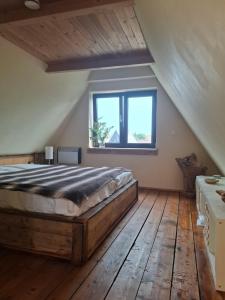 a bedroom with a large bed and a window at Ferienhaus Witta in Radebeul +4 photos