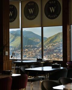 a restaurant with tables and chairs with mountains in the background at Wan Hotel in Duhok