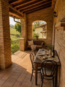 an outdoor patio with a wooden table and chairs at Il Castelletto di Gomo - Relax nella natura con SPA privata outdoor in Godiasco