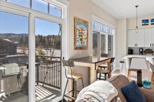 a living room with a couch and a kitchen with a balcony at Downtown WP Corner Loft 24 I Hot Tub I Great Views I Bunk Beds I Activity Program in Winter Park