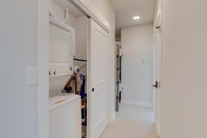 a hallway with white walls and a door with a mirror at Downtown WP Corner Loft 24 I Hot Tub I Great Views I Bunk Beds I Activity Program in Winter Park