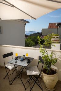 a table and chairs on a balcony with a window at Jakov & Antonia Heritage Estate in Hvar
