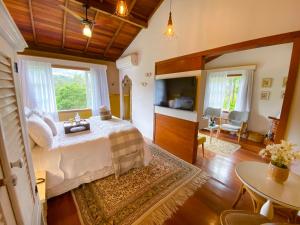 a bedroom with a bed and a living room at Pousada Rabo do Lagarto in Pedra Azul