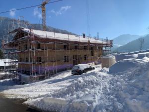 a building under construction in the snow at Ferienhof Haug in Bad Hindelang