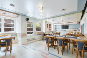 a dining room with wooden tables and chairs at Hotel an der Hörn in Kiel
