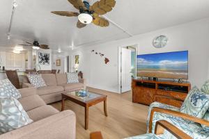 a living room with a couch and a flat screen tv at Kanai A Nalu 202 in Wailuku