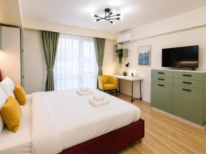 a bedroom with a bed with a television and a desk at Victoriei Studio Old City in Bucharest