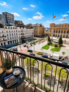 a balcony with a table and a view of a city at Victoriei Studio Old City in Bucharest