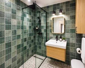 a green tiled bathroom with a sink and a shower at Victoriei Studio Old City in Bucharest +18 photos