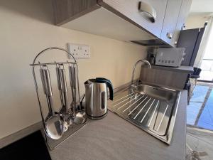 a kitchen counter with a sink and utensils at Brand new Oceanview Penthouse by MaBeLi in St. Paul's Bay +23 photos