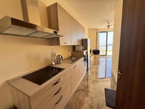 a kitchen with a sink and a refrigerator at Brand new Oceanview Penthouse by MaBeLi in St. Paul's Bay